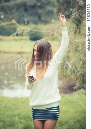 young beautiful woman girl autumn listening music 13834810