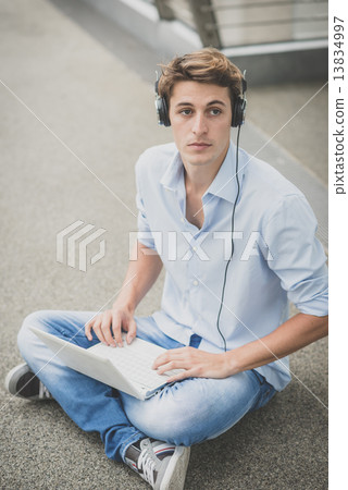 young model hansome blonde man with notebook and headphones young model hansome blonde man with notebook and headphones 13834997