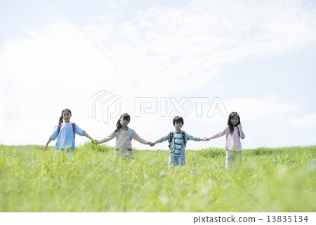Elementary school student holding hands in the field Elementary school student holding hands in the field 13835134