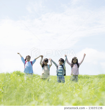 Elementary school student holding hands in the field Elementary school student holding hands in the field 13835136