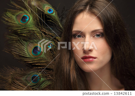 beautiful girl on a background of feathers 13842611