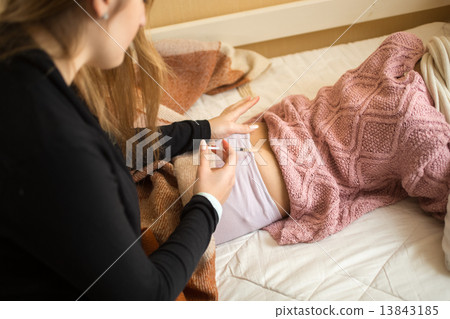 woman doing injection in girls bottom lying on bed woman doing injection in girls bottom lying on bed 13843185