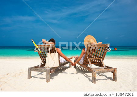 Couple in white relax on a beach at Maldives Couple in white relax on a beach at Maldives 13847201