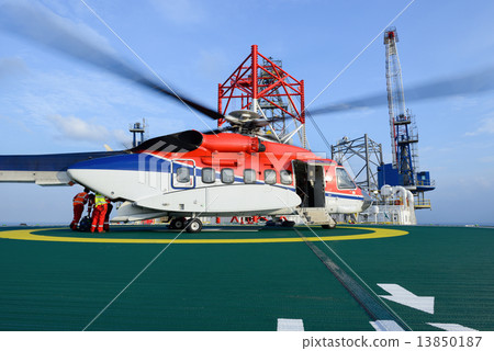 The worker are loading baggage of passenger to helicopter at oil 13850187