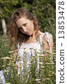 Photo of young blonde woman sitting near achillea bushes 13853478
