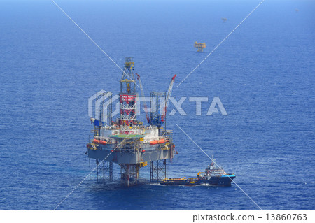 The offshore drilling oil rig and supply boat side view 13860763