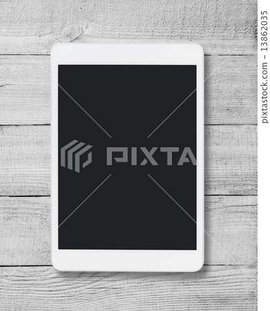 Tablet pc on wood table background 13862035