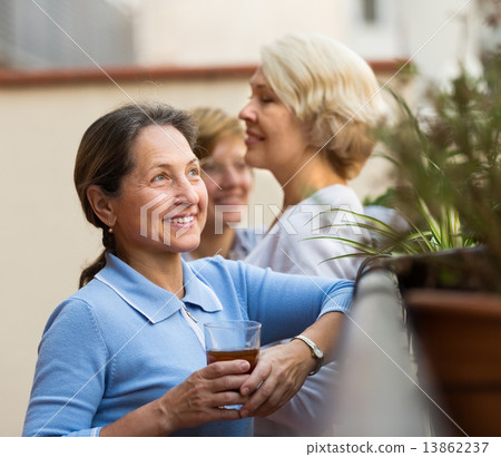 Three women drinking tea at balcony 13862237