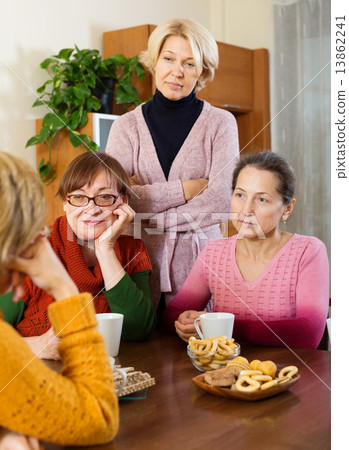 pensioners listening to sad story of their friend in pensioners listening to sad story of their friend in 13862241