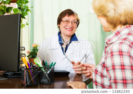 Mature doctor having good news for a patient Mature doctor having good news for a patient 13862293