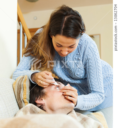 woman dripping collyrium to man 13862704