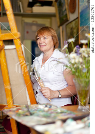 Female artist paints a picture on canvas 13862765
