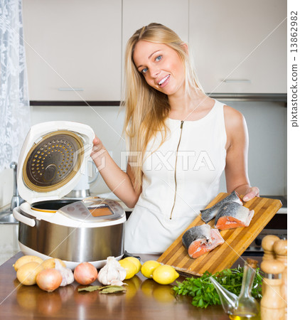 Woman cooking with multicooker Woman cooking with multicooker 13862982