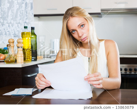 serious girl reading document at home 13863079