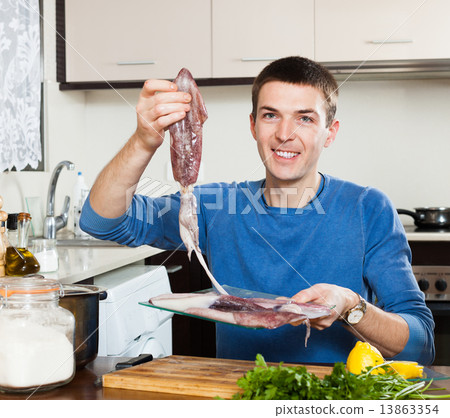 Ordinary smiling man with raw squid 13863354