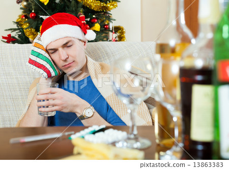 Young sick man in red New Year hat 13863383