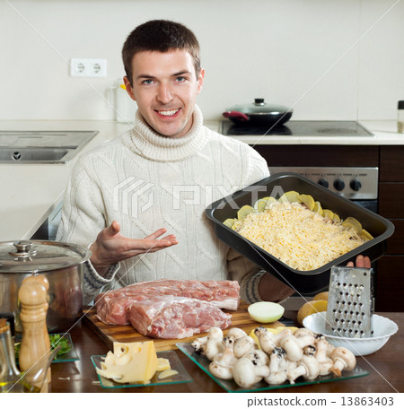 Ordinary man cooking french-style meat at home Ordinary man cooking french-style meat at home 13863403