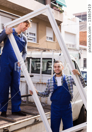 Two workers delivering PVC profiles 13863419