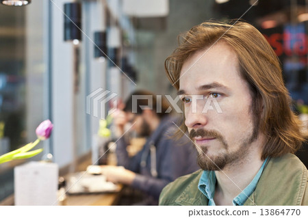 Portrait of a pensive and handsome young man in coffee shop 13864770