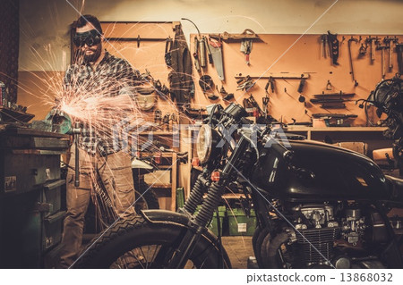 Mechanic doing lathe works in motorcycle customs garage Mechanic doing lathe works in motorcycle customs garage 13868032