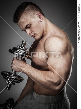 Stock Photo: Handsome young muscular man exercising with dumbbells