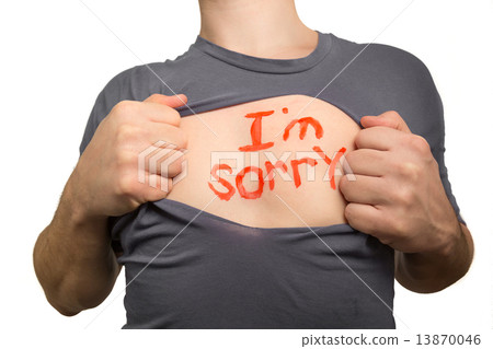 Man tearing apart grey t-shirt. Red text I am sorry written on h Man tearing apart grey t-shirt. Red text I am sorry written on h 13870046