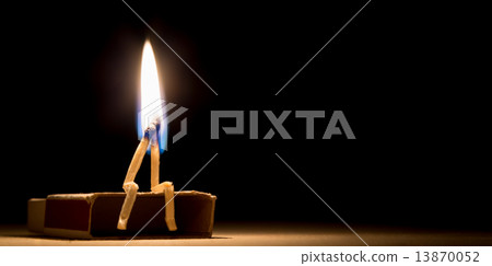 two matches burning sitting together on the matchbox in the dark 13870052