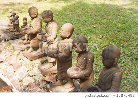 Little monk clay doll decorated in garden 13873498