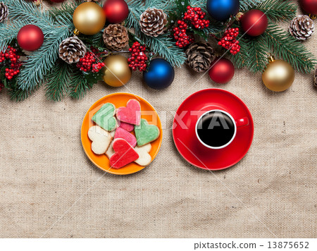 Hot coffee and cookie on a table near pine branches 13875652