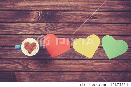 Cup with coffee and heart shape papers on wooden table. Cup with coffee and heart shape papers on wooden table. 13875864