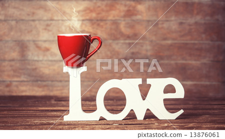 Tea or coffee cup with word Love on woodent table. Tea or coffee cup with word Love on woodent table. 13876061