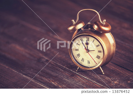 Retro alarm clock on a table. Photo in retro color image style Retro alarm clock on a table. Photo in retro color image style 13876452