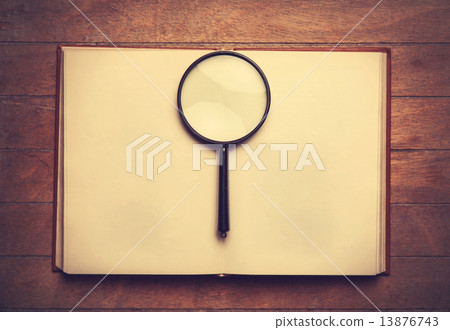 Opened book and loupe on it. 13876743
