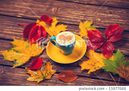 Autumn leafs and coffee cup on wooden table. Autumn leafs and coffee cup on wooden table. 13877088