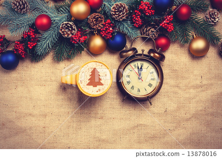 Hot cappuccino with christmas tree shape and alarm clock on a ta Hot cappuccino with christmas tree shape and alarm clock on a ta 13878016