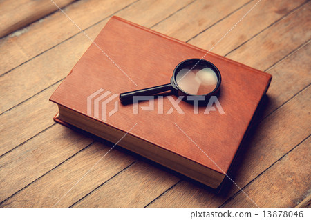Closed book and loupe on it. Closed book and loupe on it. 13878046