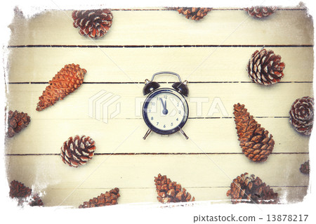 Alarm clock and pine cone spruce on a wooden table. Alarm clock and pine cone spruce on a wooden table. 13878217