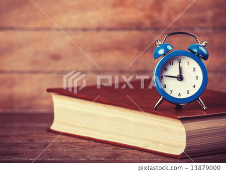 Alarm clock and book. Alarm clock and book. 13879000