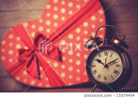 Retro clock and gift in heart shape on the background. Retro clock and gift in heart shape on the background. 13879494