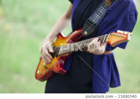 Close-up view at guitar in girl's hands at outdoor. 13880340