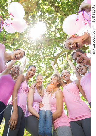 Smiling women in pink for breast cancer awareness 13881538