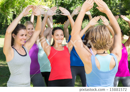 Fitness group warming up in park 13881572