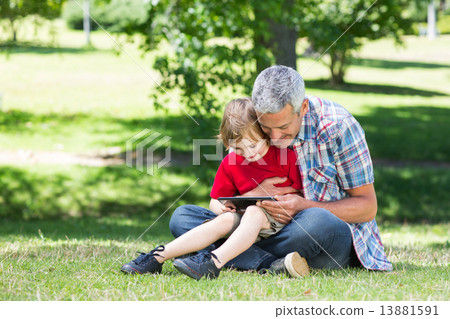Happy father using tablet pc with his son 13881591
