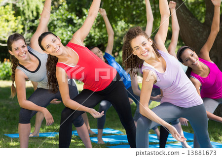Fitness group doing yoga in park 13881673