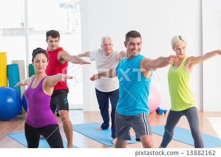 People doing warrior pose in yoga class 13882162