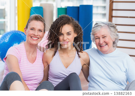 Portrait of female friends sitting in gym 13882163