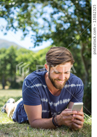 Handsome hipster using phone in park Handsome hipster using phone in park 13882325