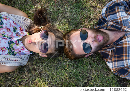 Young couple lying on grass smiling at camera 13882662