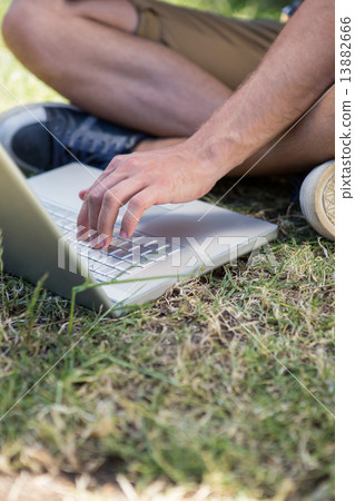 Man using laptop in park 13882666