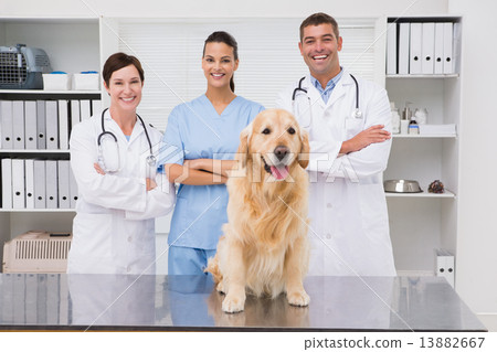 Veterinarian coworker smiling at camera with dog 13882667